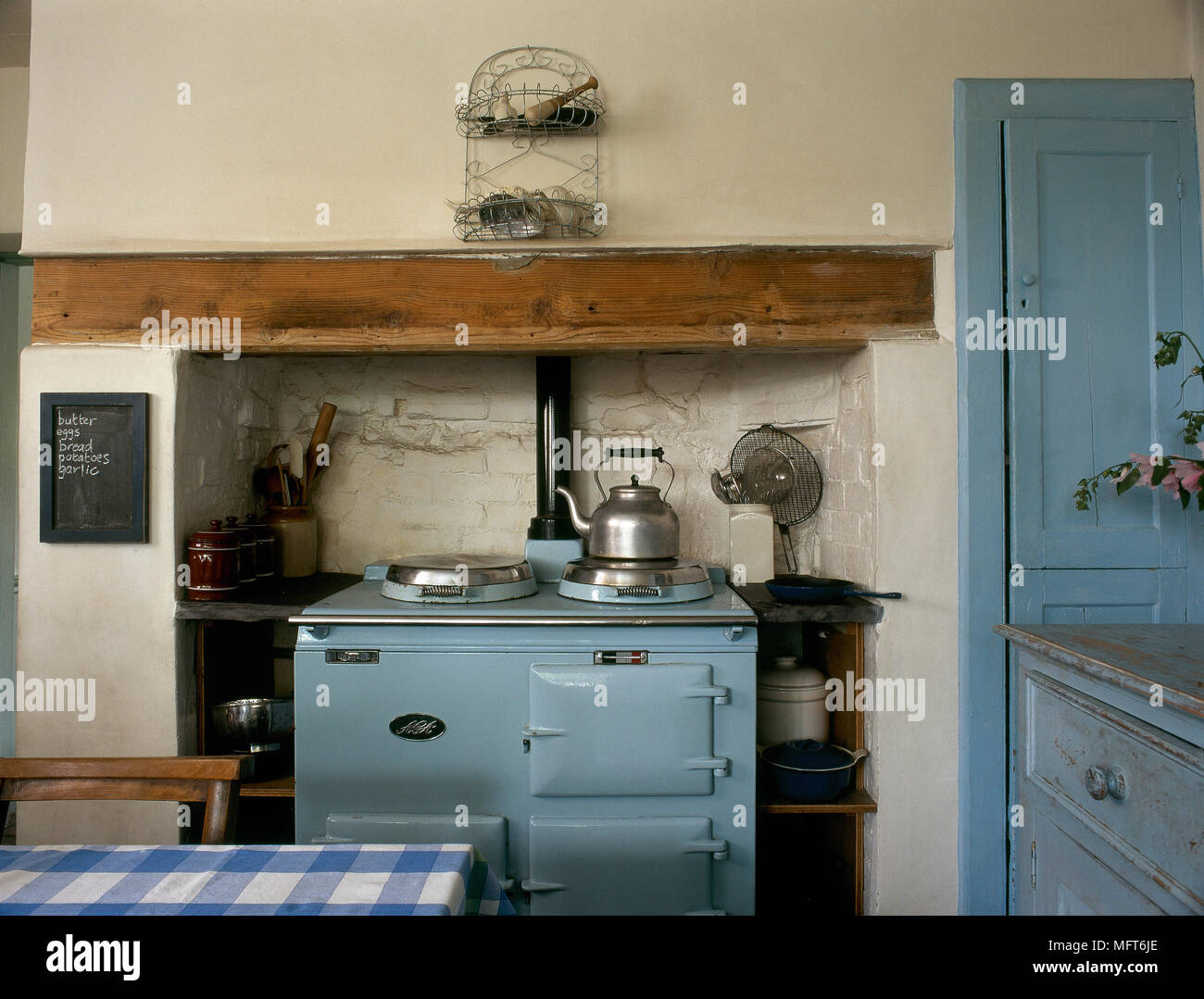 Country Kitchen With Distressed Cabinets And A Blue Oven In A Wall