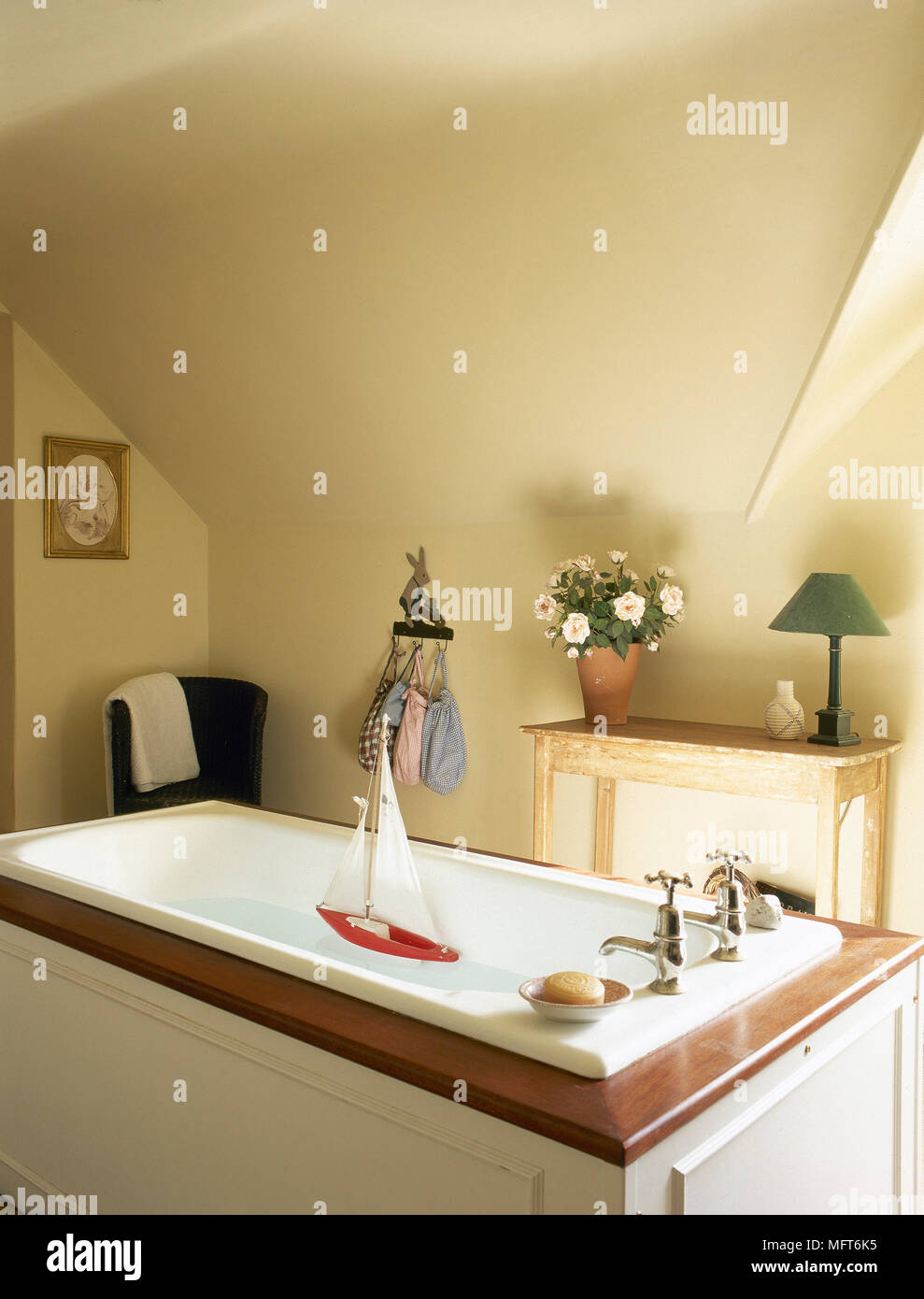 Country Yellow Bathroom With A Sloping Ceiling Wooden Table And