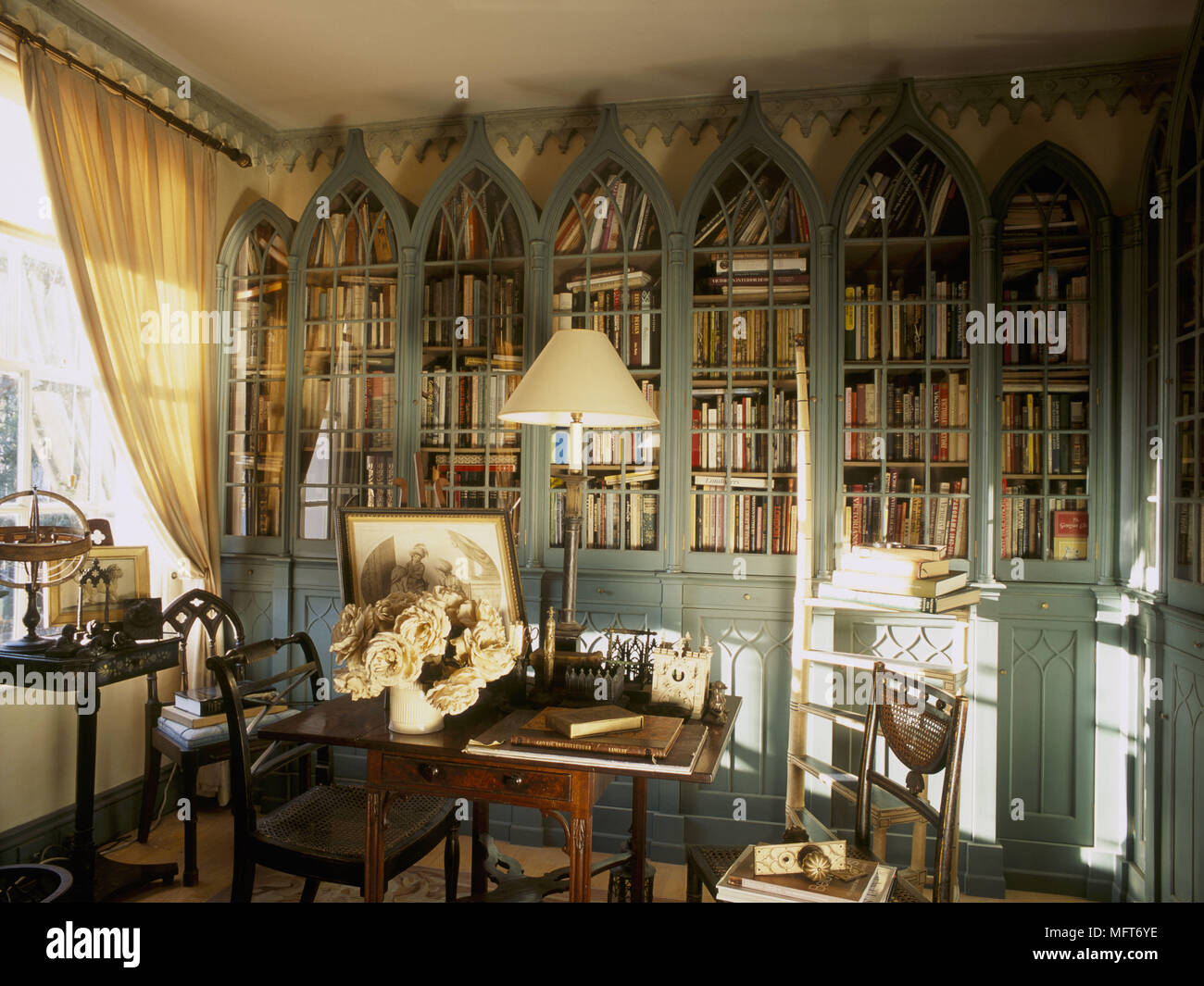 A traditional yellow library room built in painted book cases with