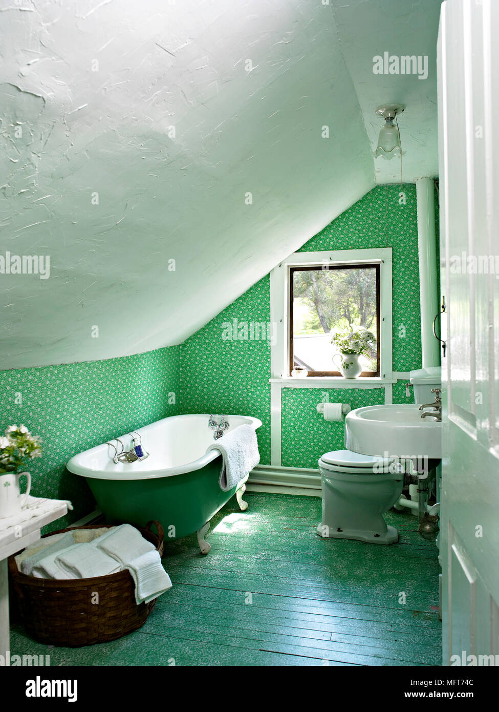 Freestanding roll top bath and wash basin in green bathroom Stock Photo - Alamy