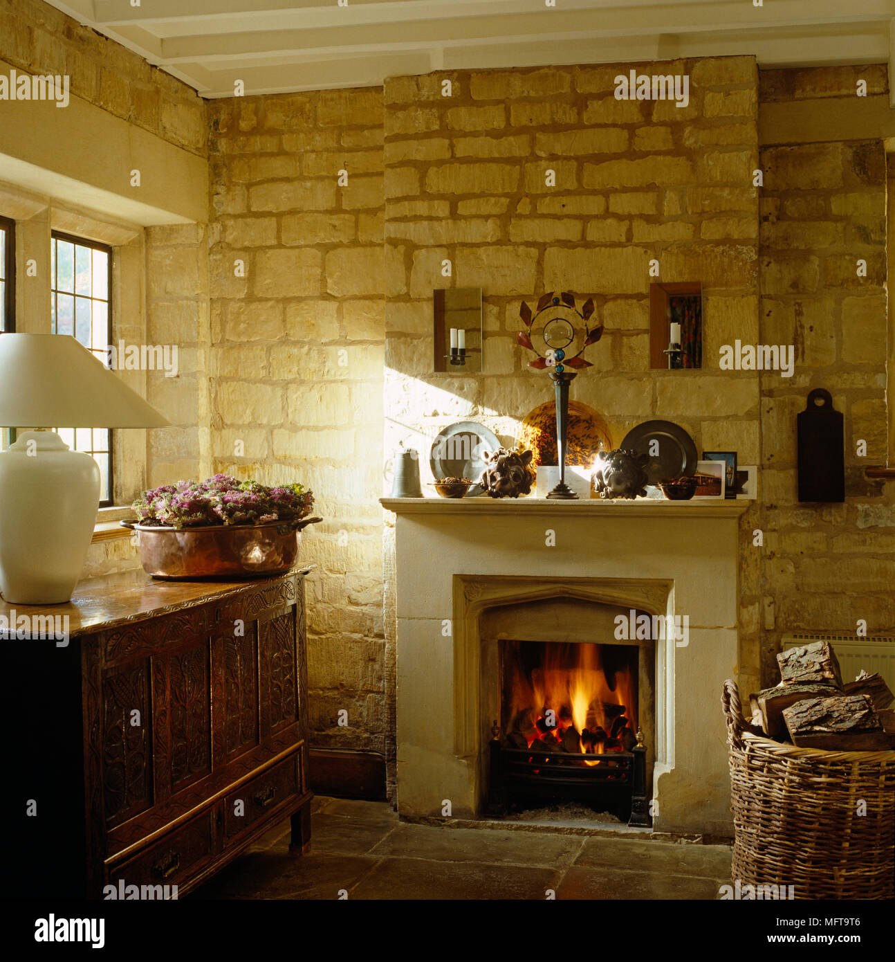 Lit Fire In Fireplace In Country Style Room With Exposed Stone