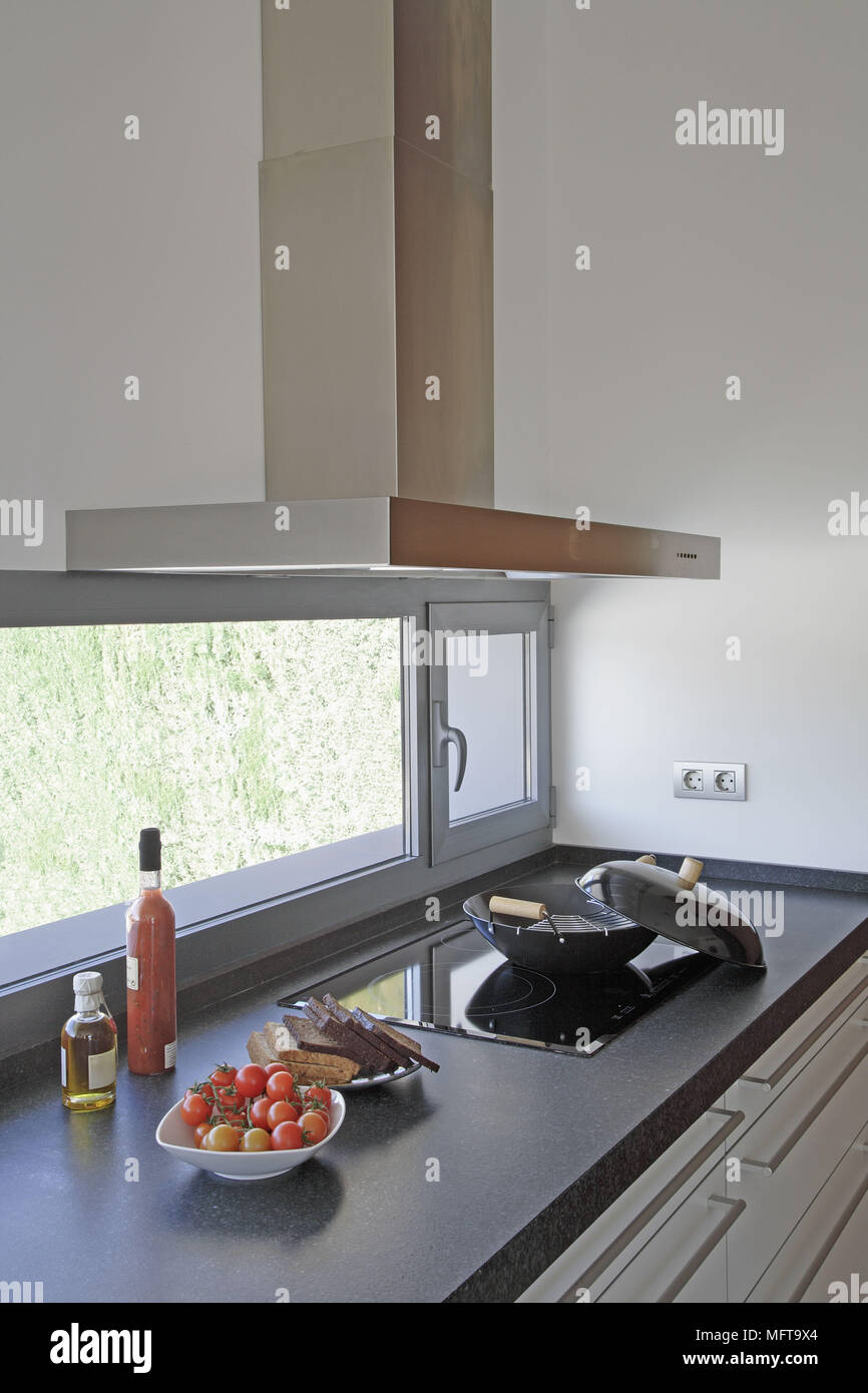 Cooker hood above pan on hob with food on plates Stock Photo Alamy