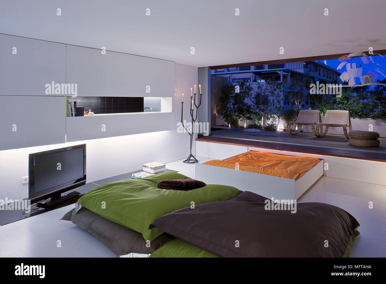 Floor Cushions In Front Of Widescreen Television In Modern Room