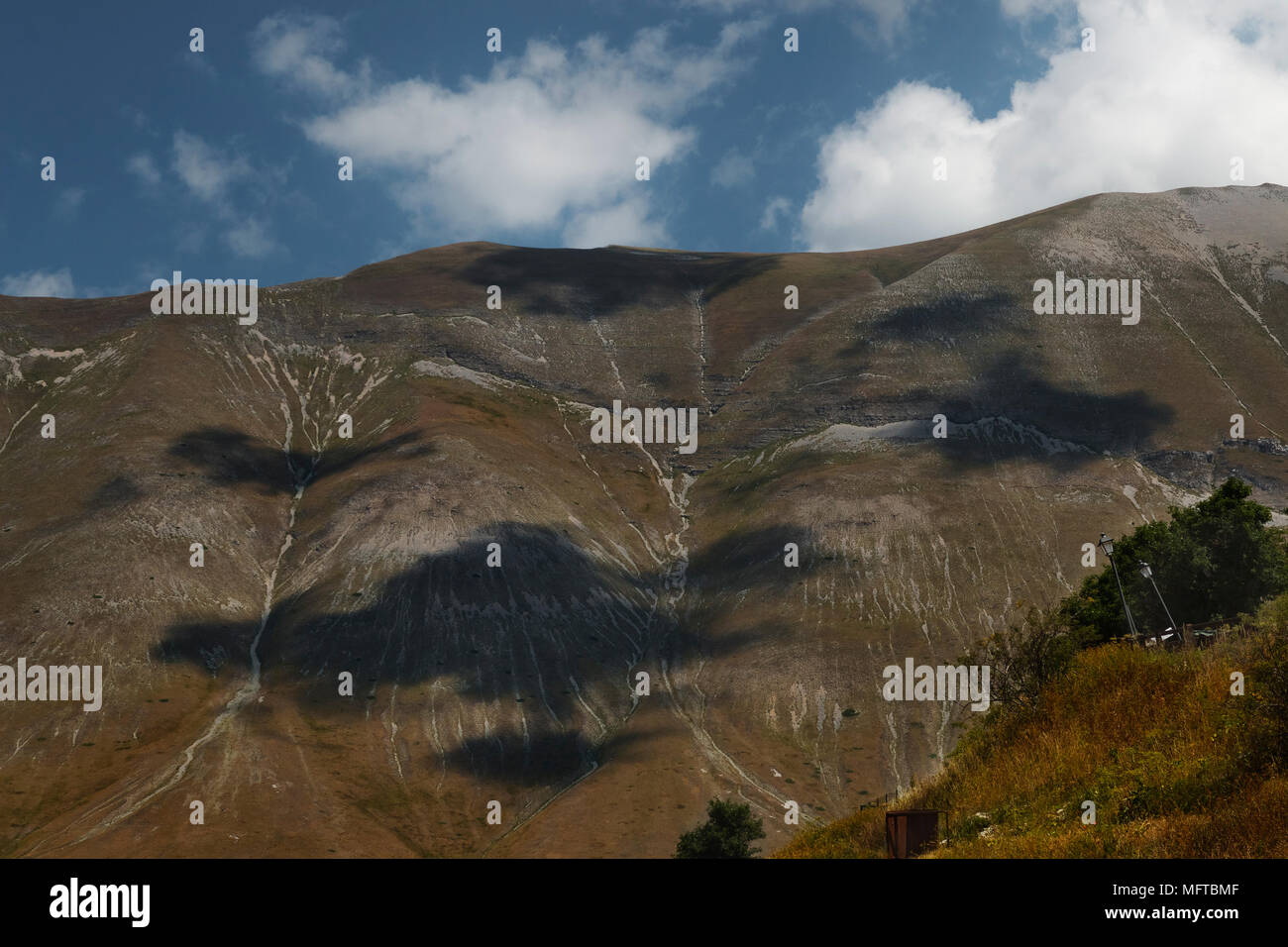 Impressive clouds shadows  on the Sibillini mountains.Amusing shapes in a sunny day, fantastic landscape Stock Photo