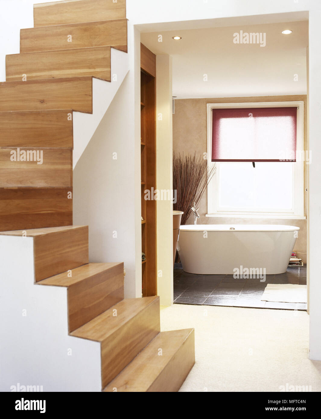 Modern hallway with wooden stairs and a view to an open bathroom with