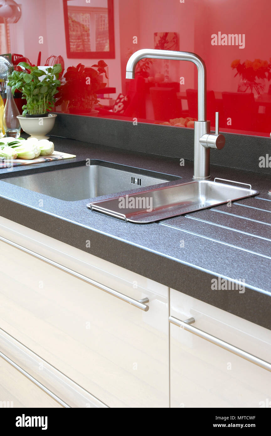 Sink set in worktop in modern kitchen with white fitted units with