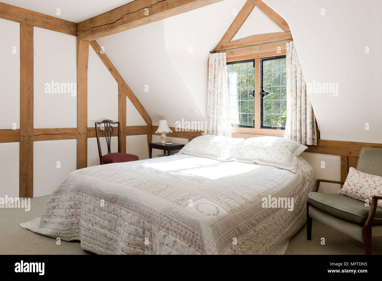 Double bed in white country style bedroom Stock Photo