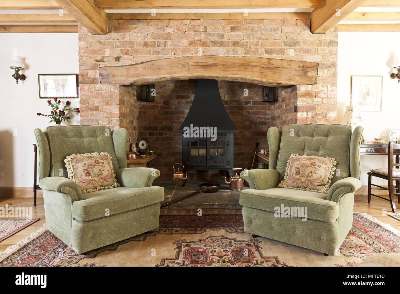 Two upholstered armchairs in front of country style fireplace