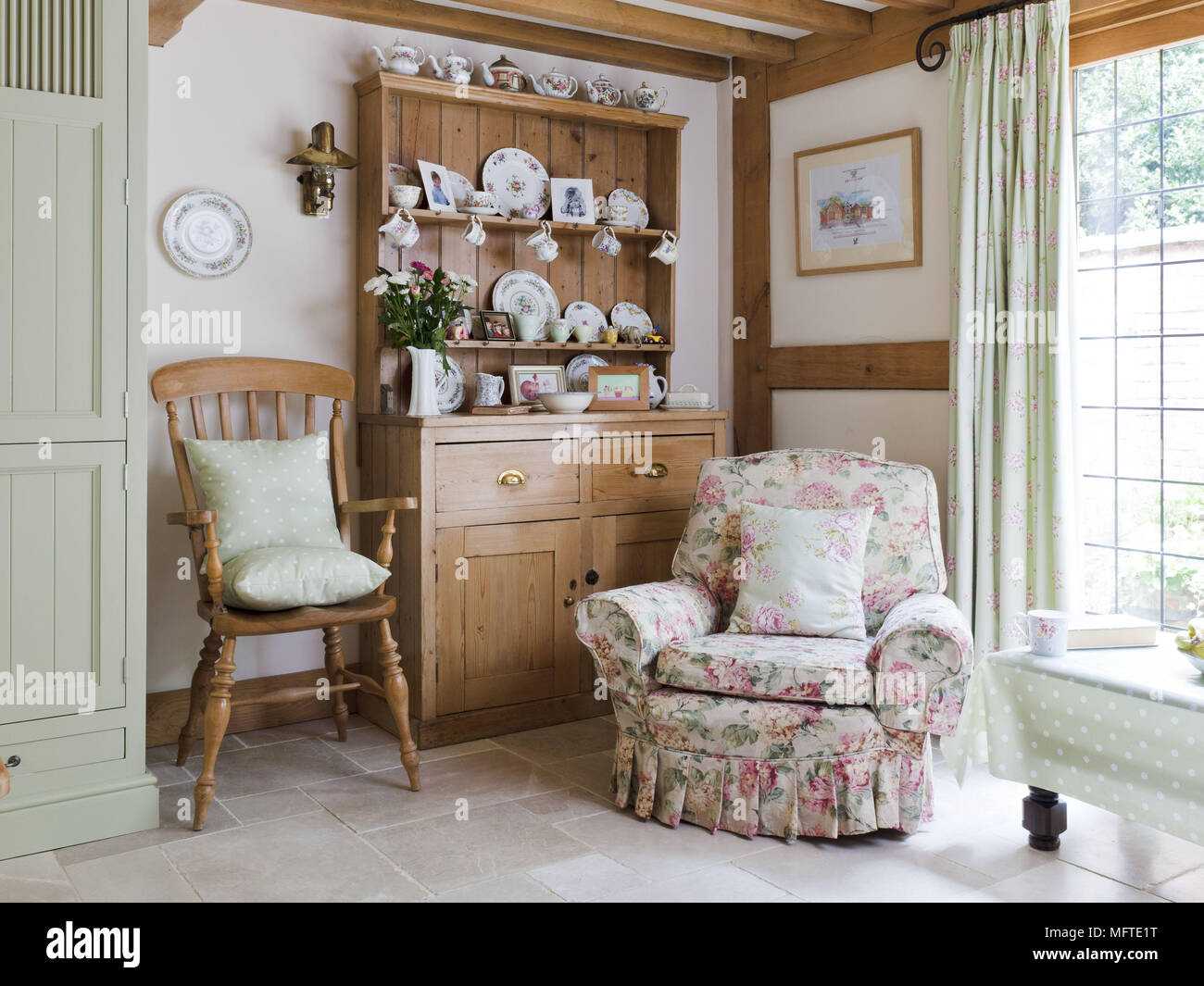 Upholstered armchair in front of dresser in country style room Stock Photo