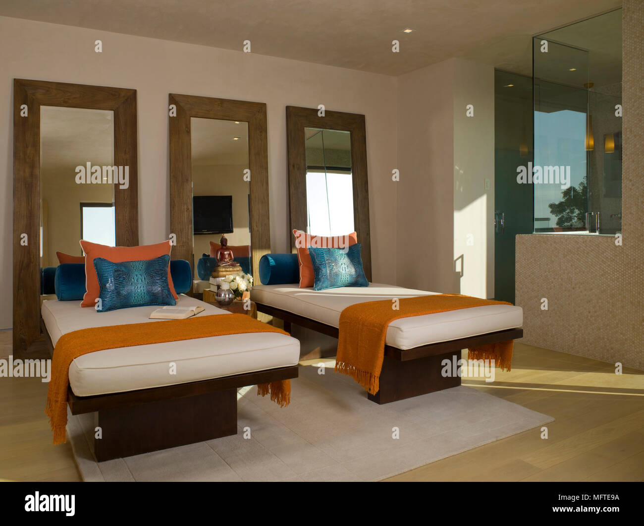 Three Mirrors Behind Two Single Beds In Modern Bedroom Stock