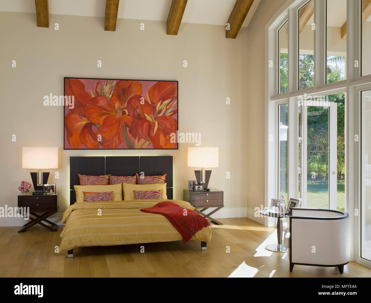 Lamps On Tables Either Side Of Double Bed In Spacious Modern