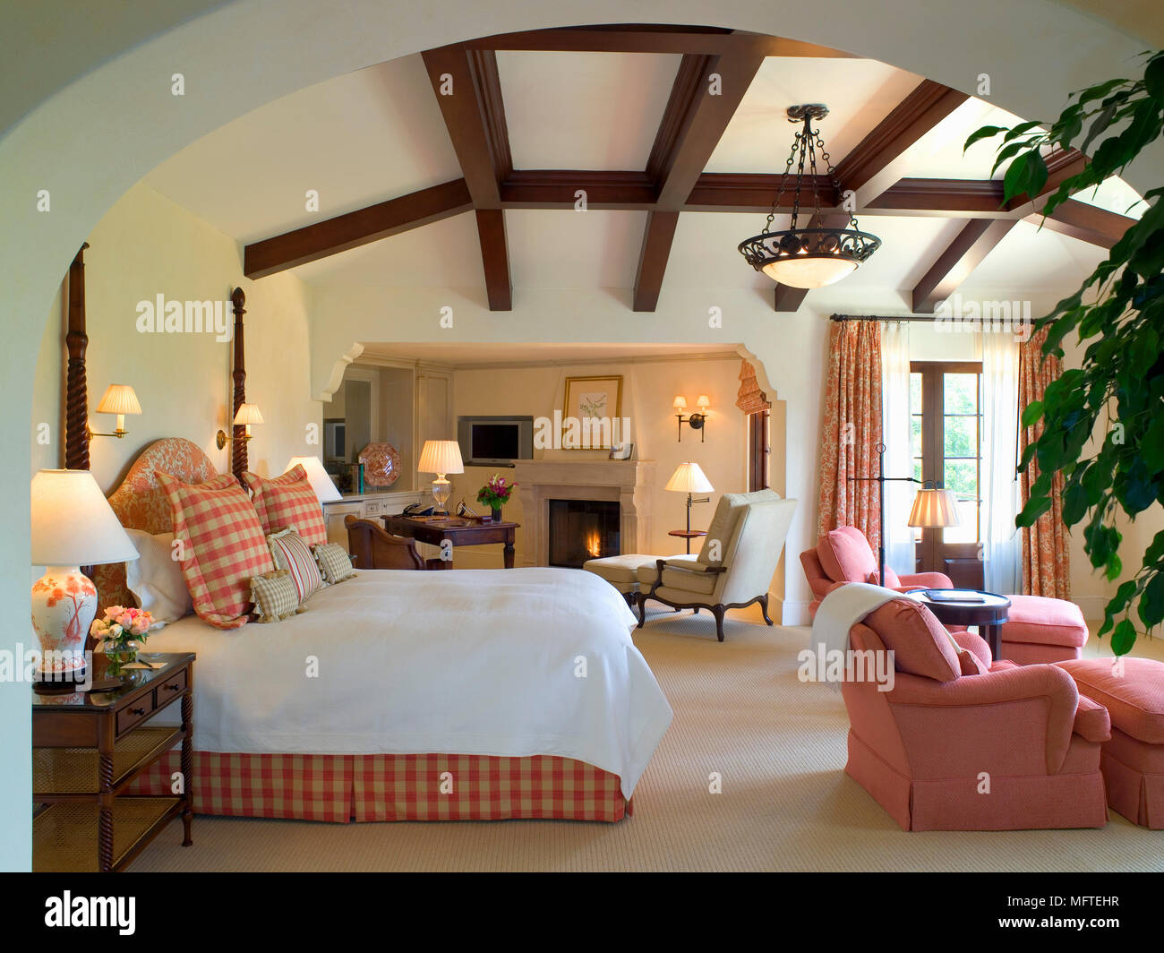 Double bed in country style bedroom with sitting area Stock Photo