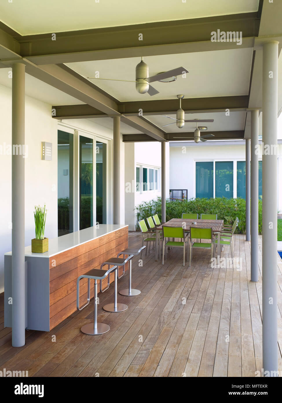 Bar stools at breakfast bar on outdoor decked terrace of modern house Stock Photo