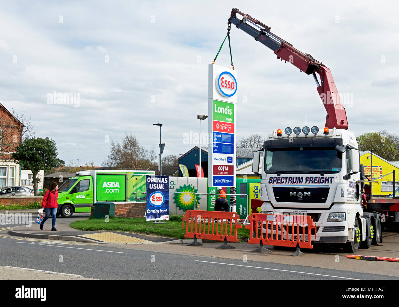 Replacing BP sign with Esso sign at a petrol station in Peterborough