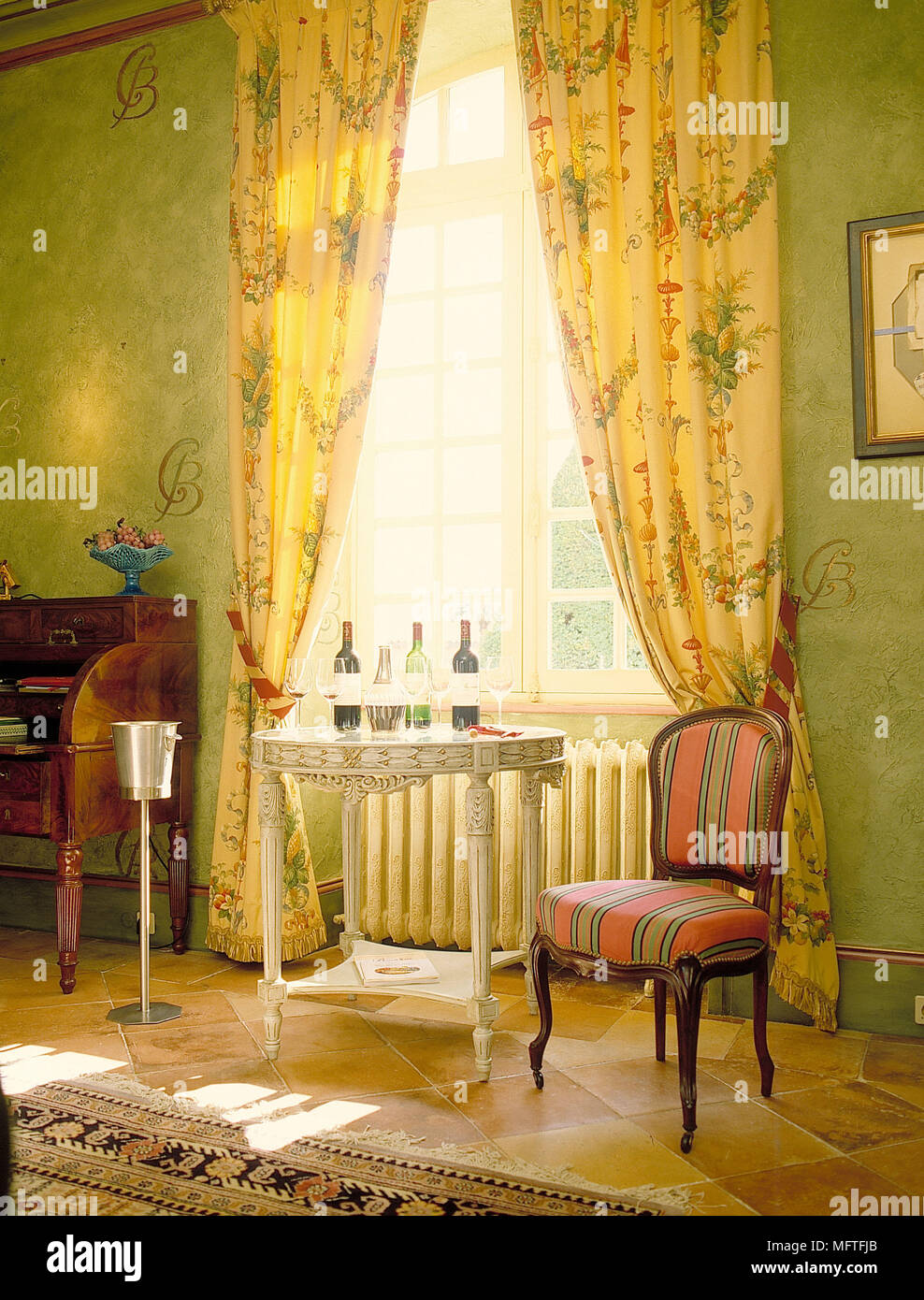 Painted table in front of window with yellow floral curtains Stock Photo Alamy