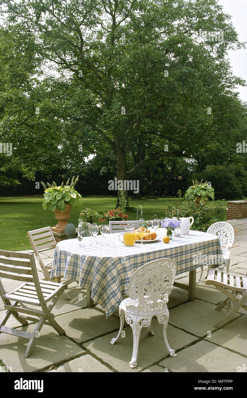 Table and wooden and metal chairs on patio in back garden Stock Photo ...
