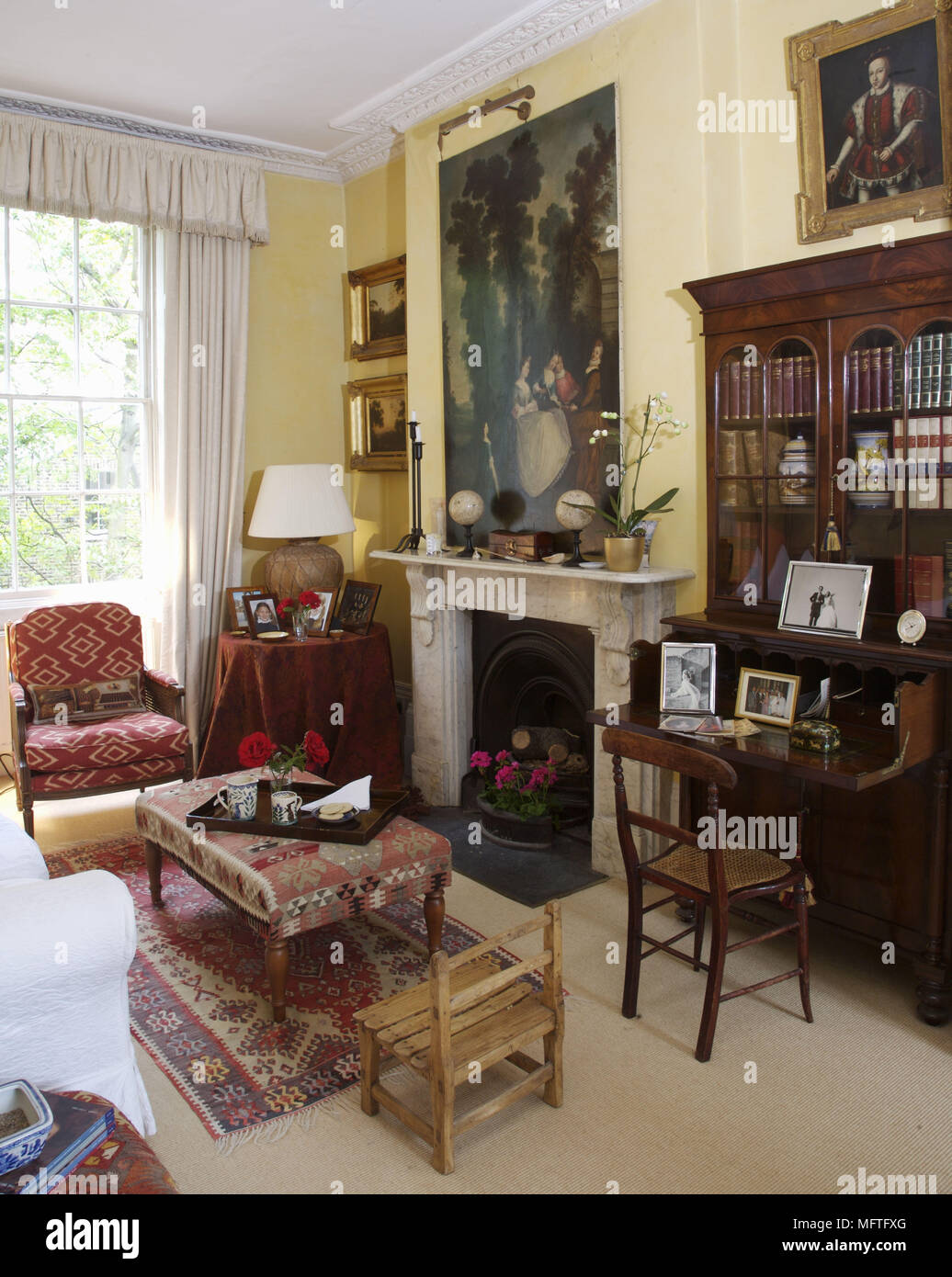 Upholstered chairs arranged in front of fireplace in traditional style sitting room Stock Photo