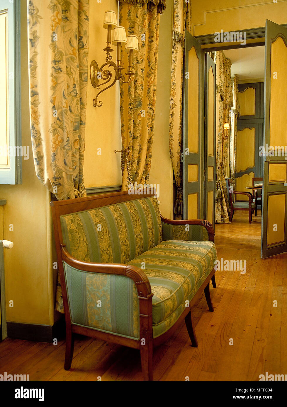 Wall lights above green and yellow striped sofa Stock Photo Alamy