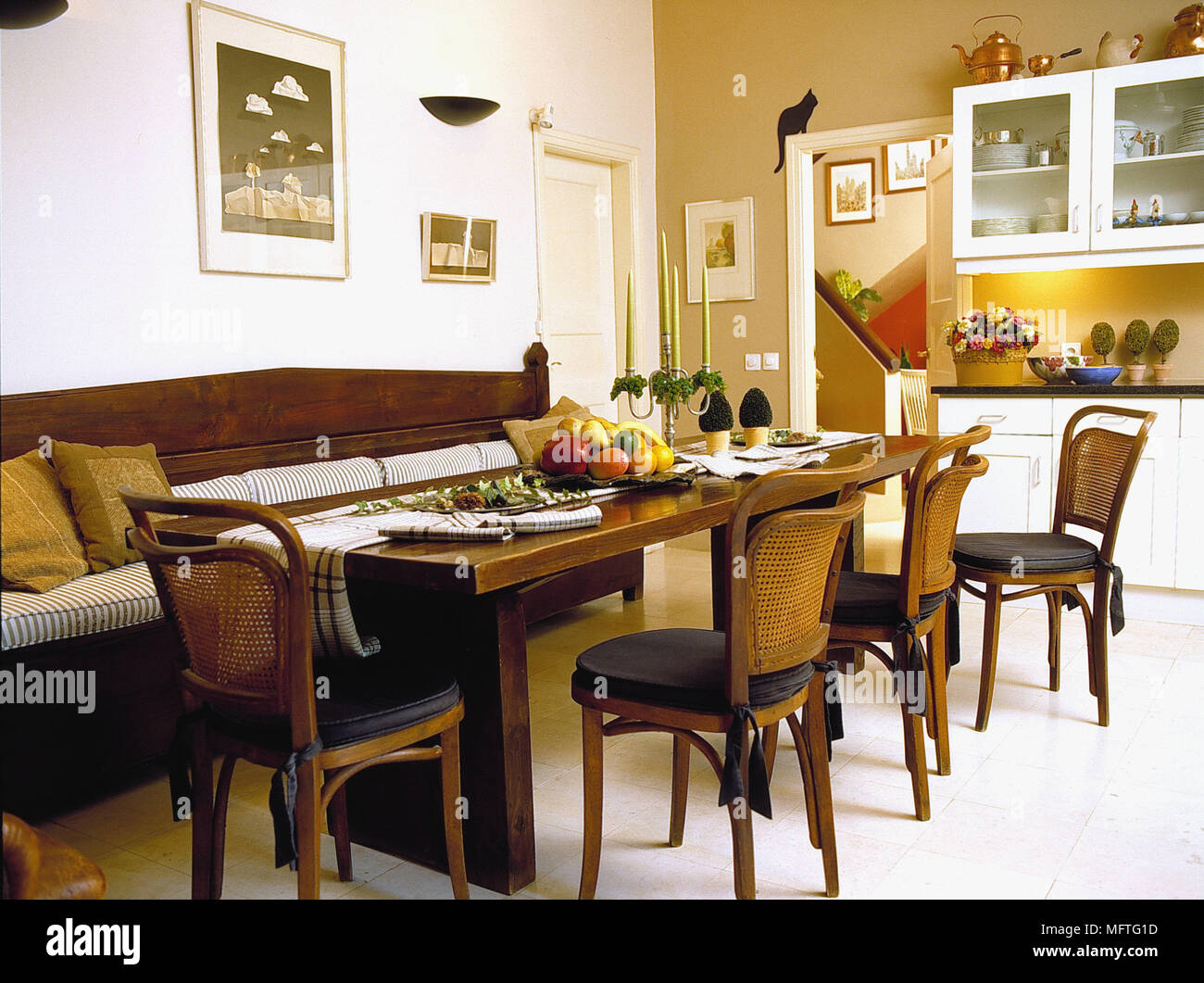 Wooden Table And Chairs And Bench Seat In Yellow Dining Room Stock