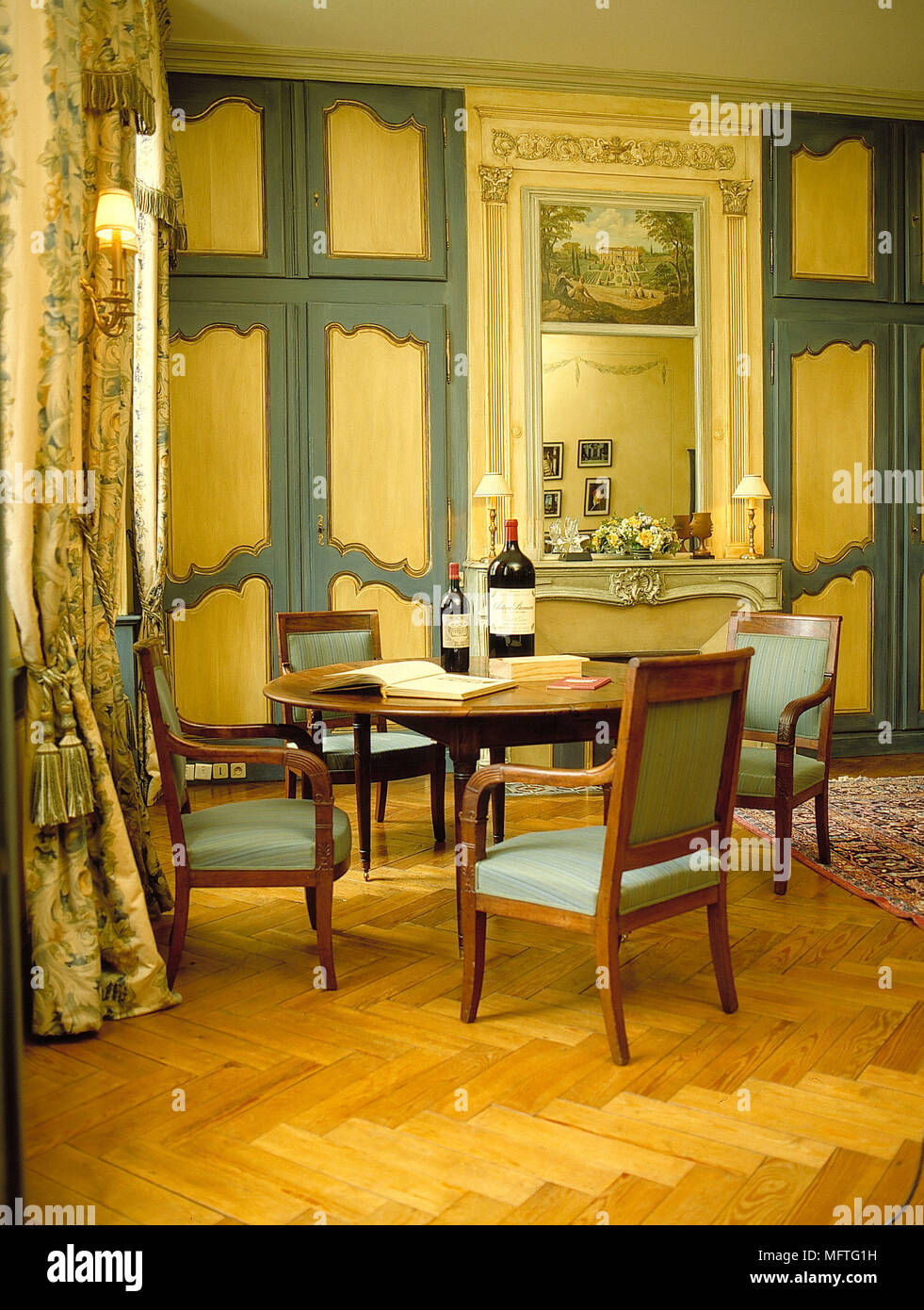 Wooden table and chairs in green and yellow dining room Stock Photo Alamy