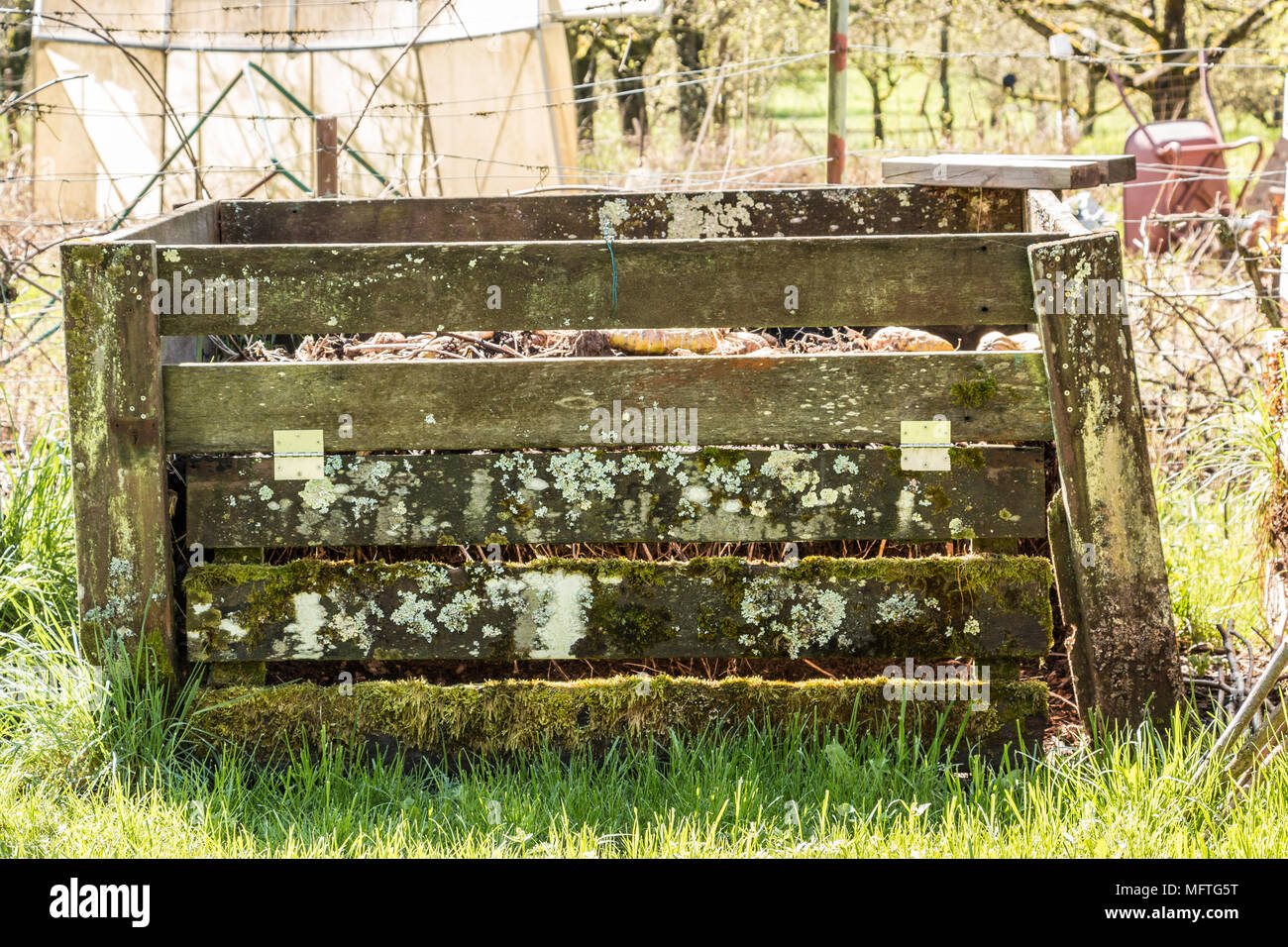 Compost heap with fertile soil in the green garden Stock Photo