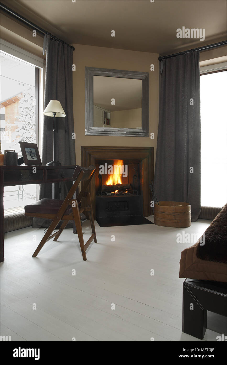 Chair At Table Next To Fireplace With Open Fire In Modern Room