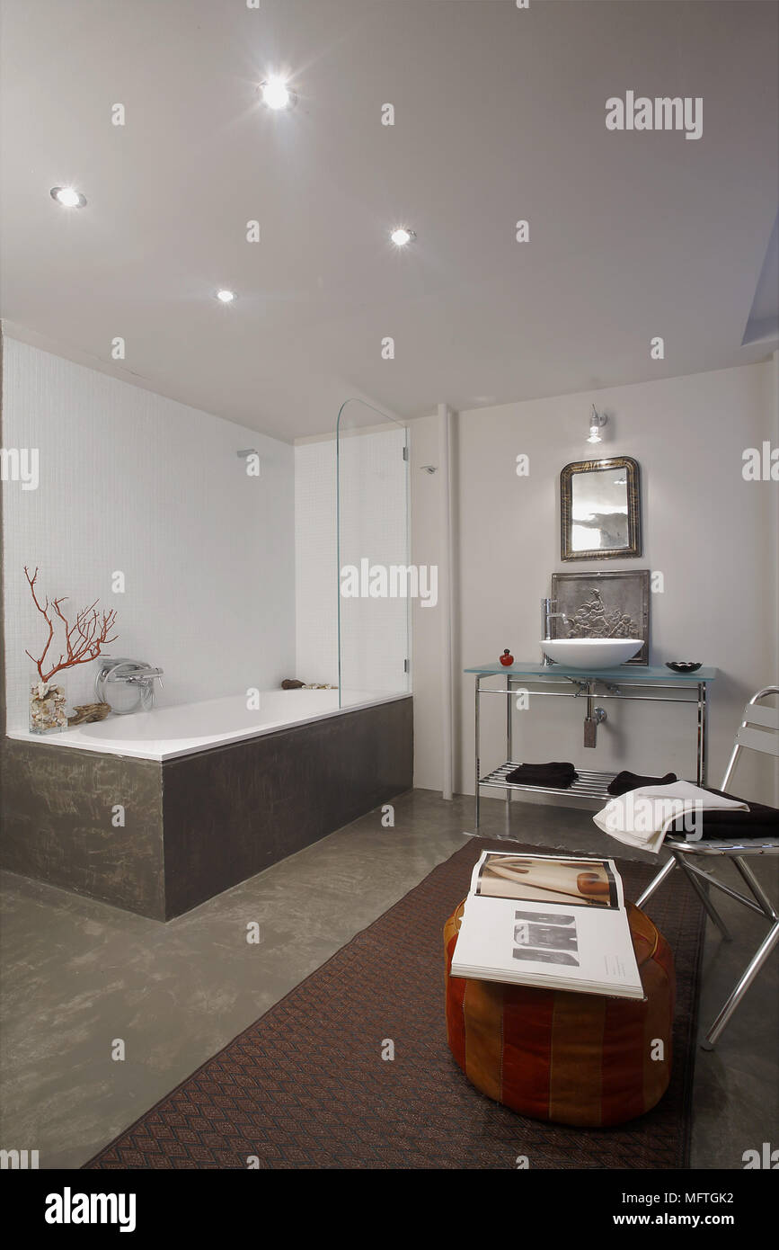 Washbasin on metal stand next to bathtub in spacious modern bathroom Stock Photo