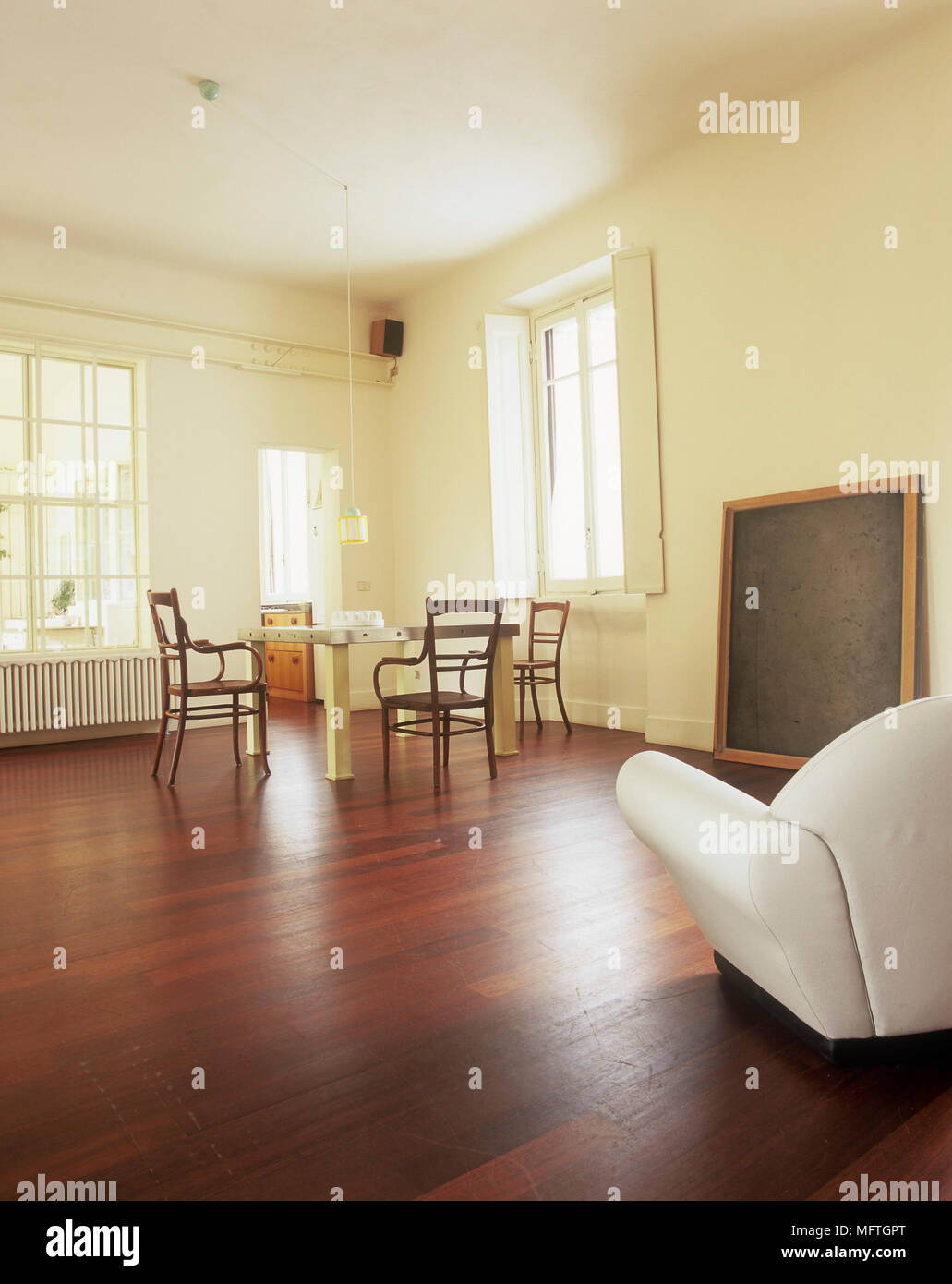 Minimalist room with dining table and chairs and leather armchair Stock ... - Minimalist Dining Table And Chairs Rental