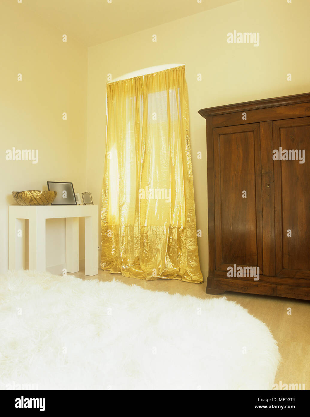 Yellow Bedroom With Gold Curtains And Freestanding Wardrobe Stock