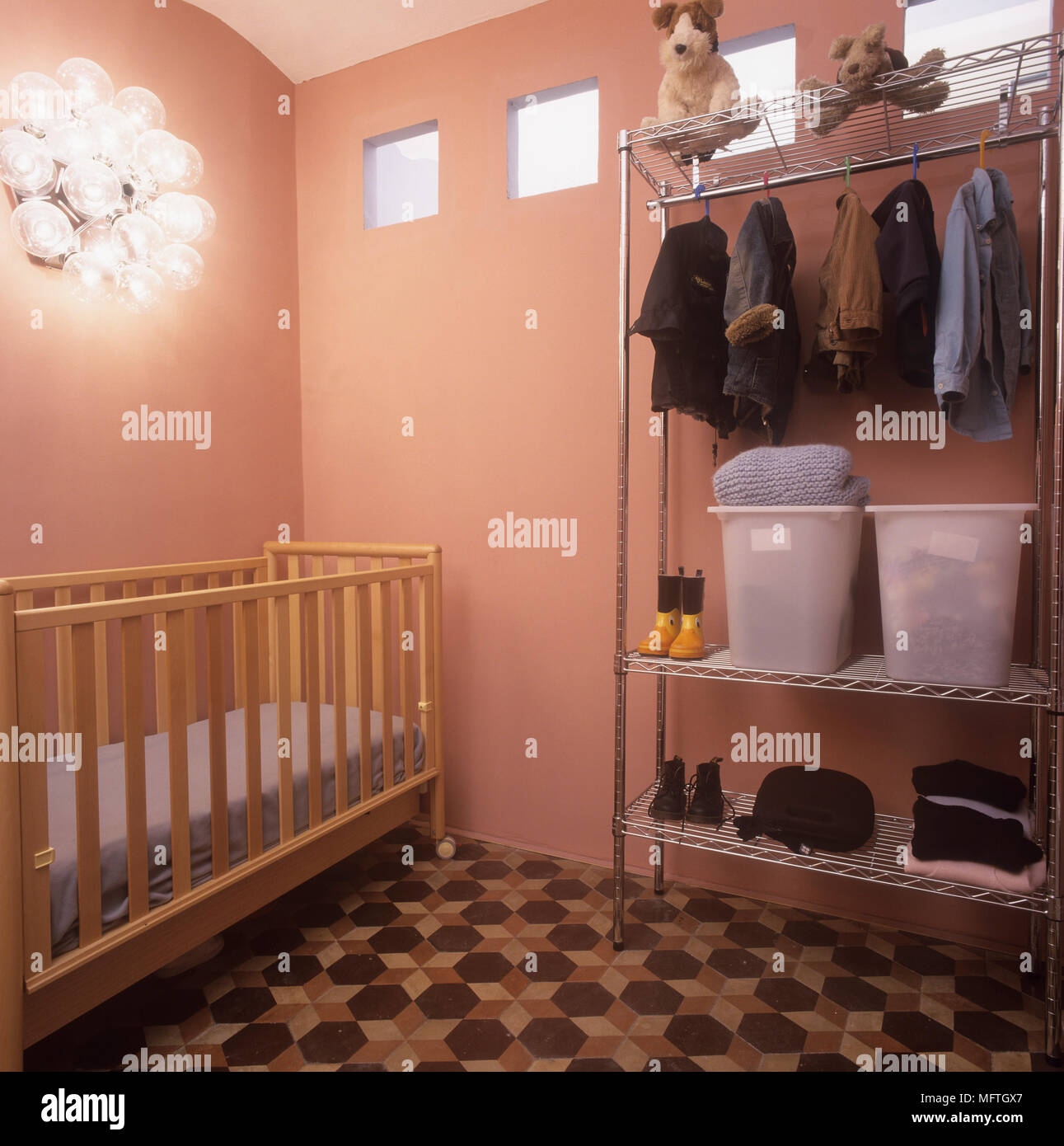 ChildÕs bedroom with a cot and metal clothes rack Stock Photo