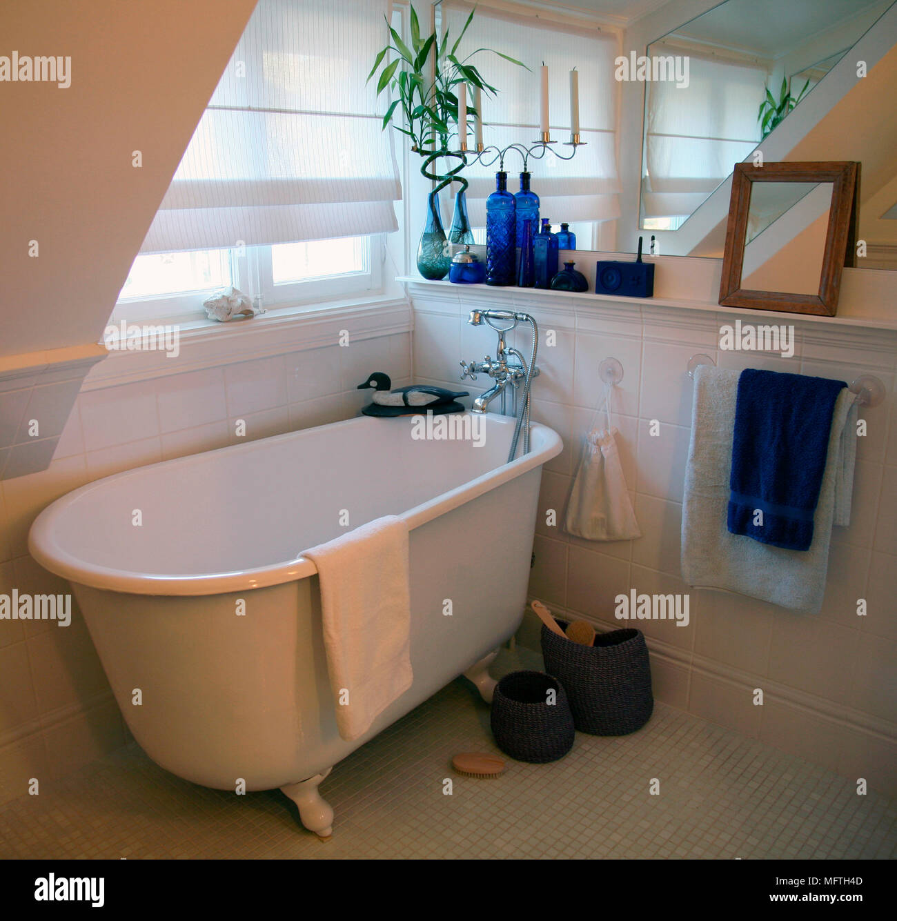 Old fashioned style freestanding roll top bathtub below window Stock