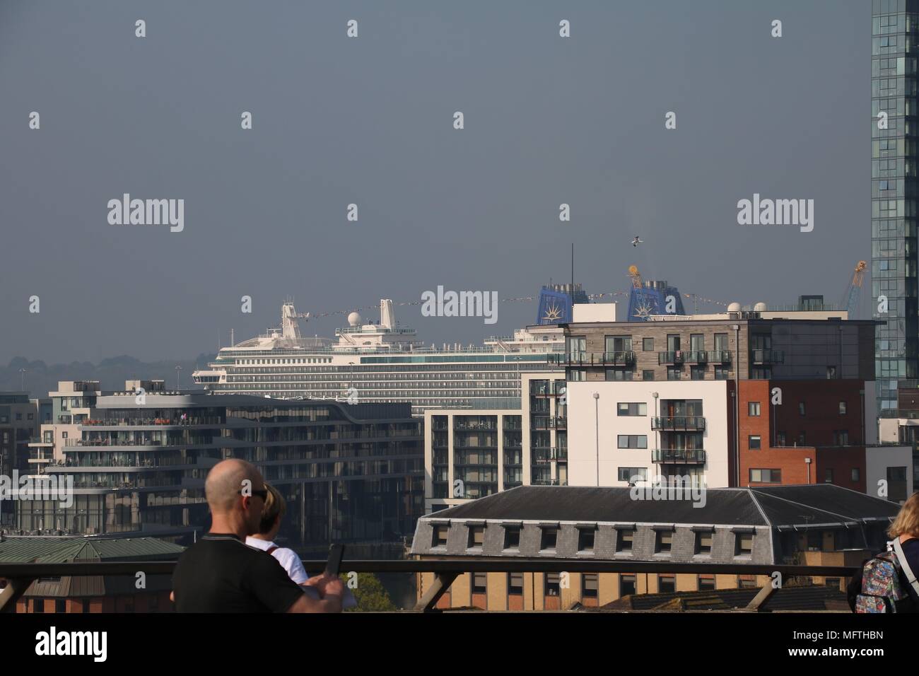A Large Cruise Ship Towering Above City Buildings At Its Mooring In 