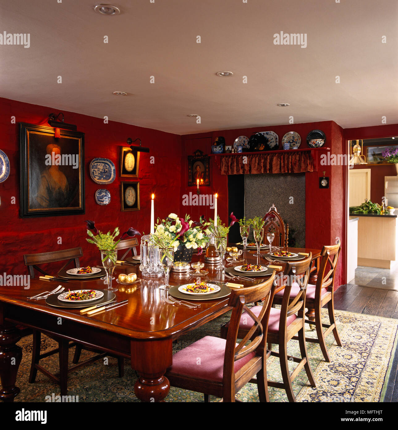 Table set for dinner in traditional red dining room with wooden