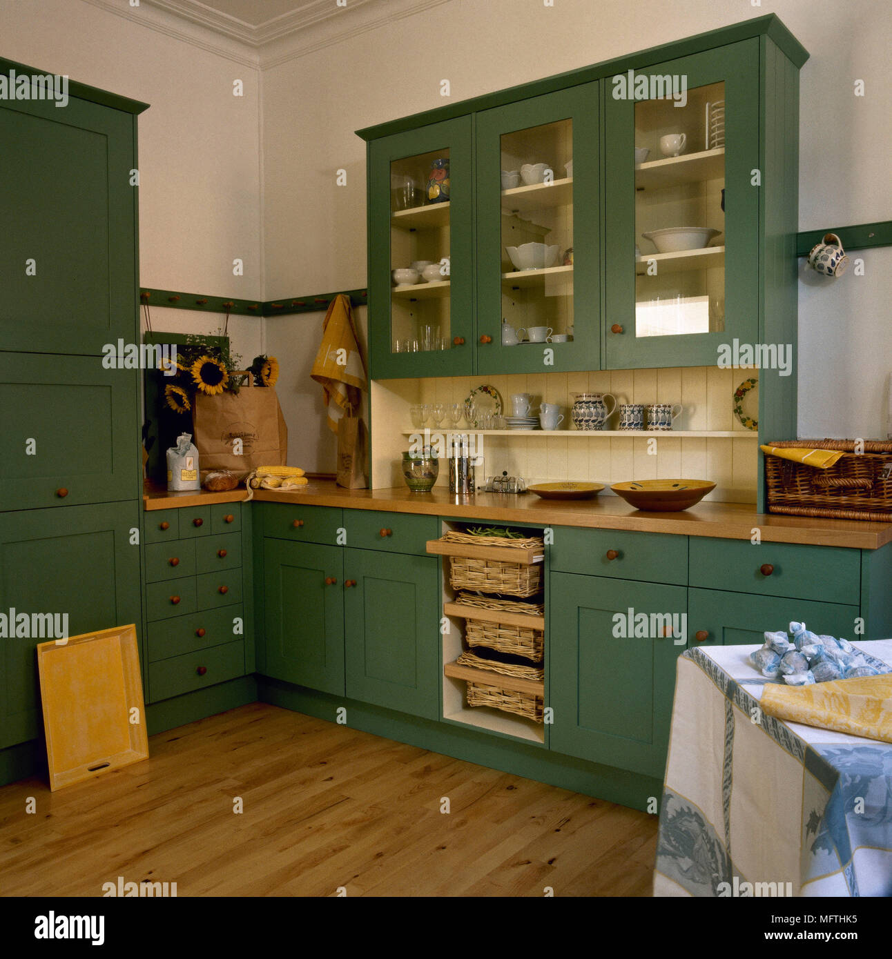 Modern, country style kitchen with green painted cabinets, wood countertops, and a wood floor. Stock Photo