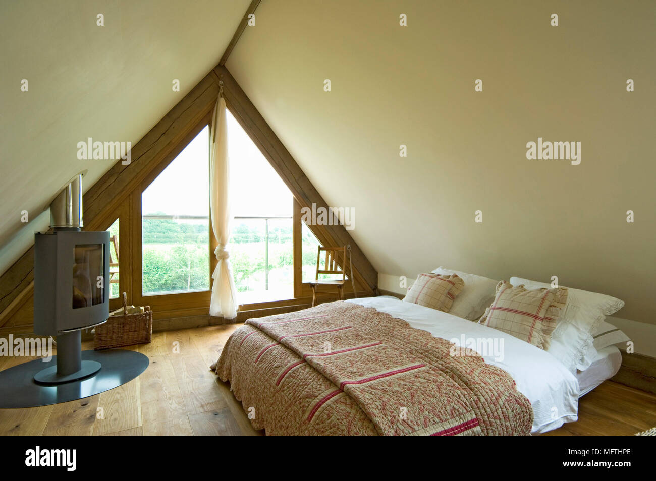 Wood Burner At Foot Of Double Bed In Yellow Bedroom With