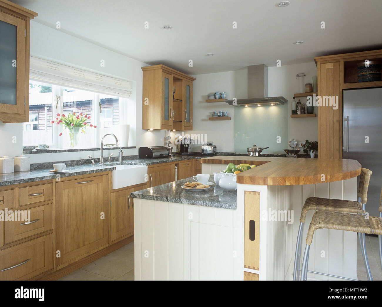 A modern kitchen with wooden cupboards, central island unit with ...