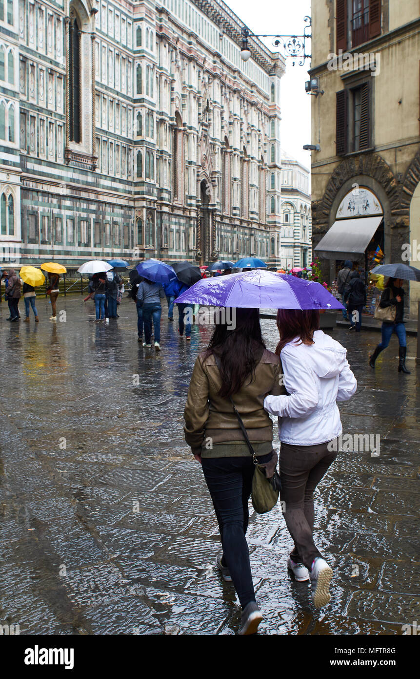 Tourists stroll beside the duomo on a rainy afternoon, Florence Italy. Stock Photo