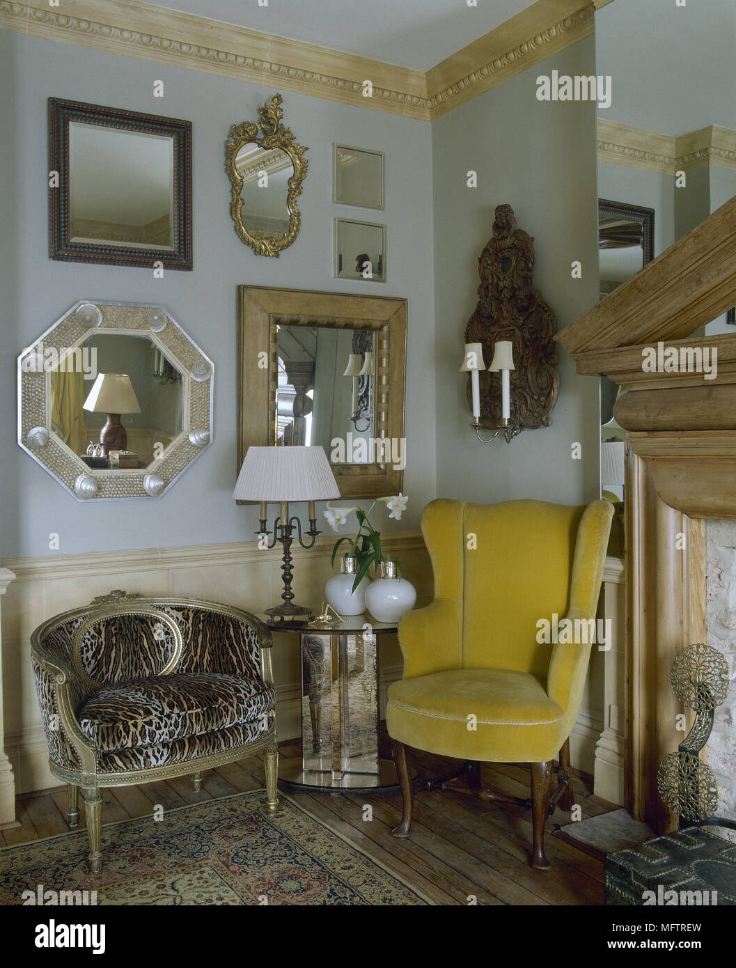 Corner of green sitting room with collection of mirrors on the wall and