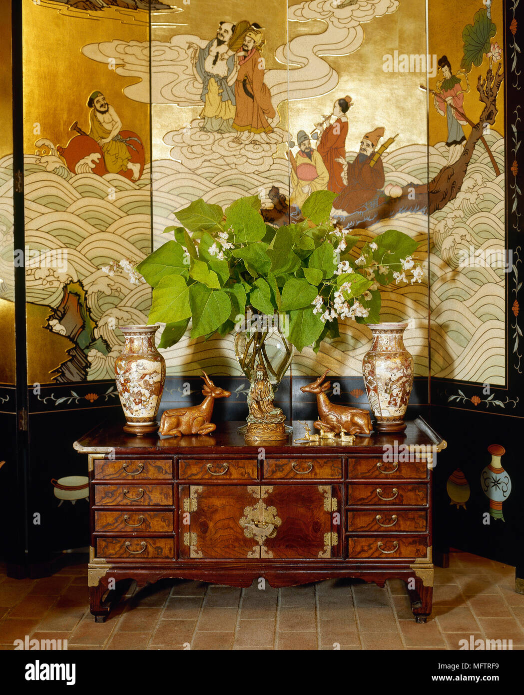 Chinese rosewood ormolu cabinet in front of painted Chinese screen, Stock Photo