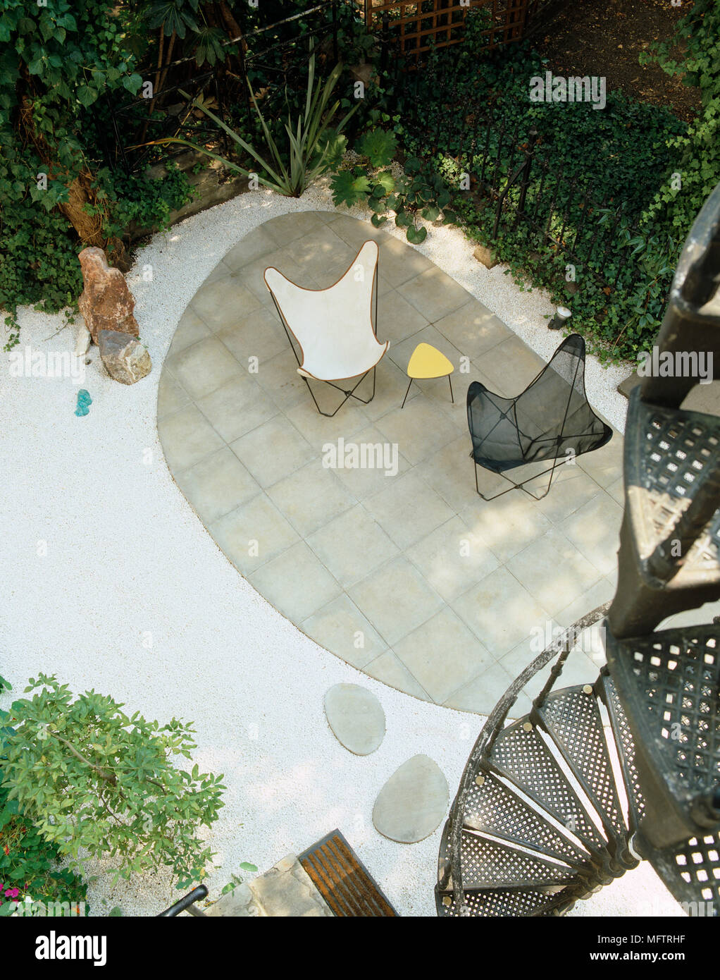 Above view of metal chairs on paved patio area of town garden Stock Photo