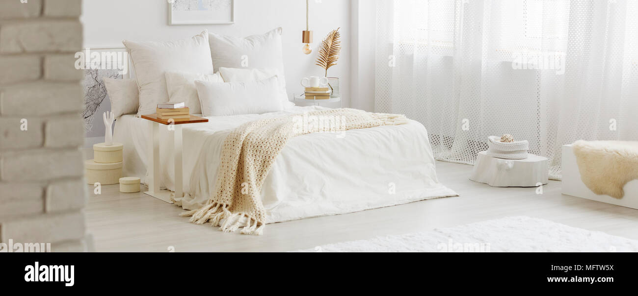 White bedroom interior with windows, gold accessories and white