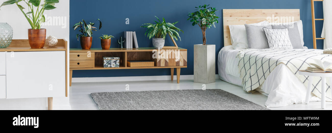 Open space bedroom interior with kingsize bed with patterned bedding