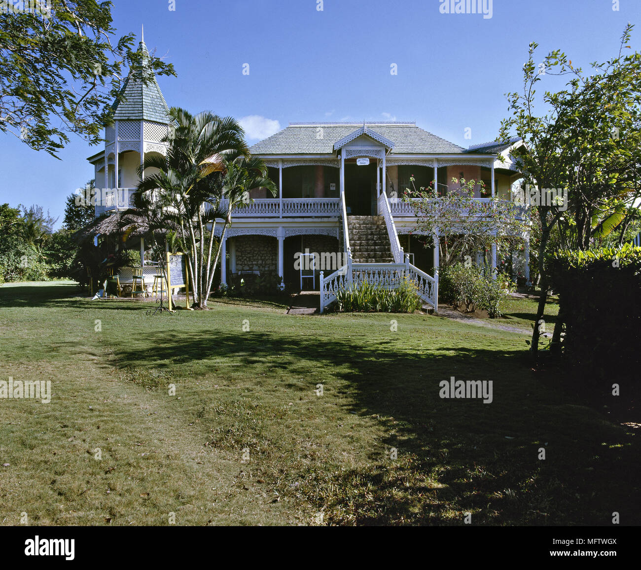 An exterior of a Jamaican weather board house with veranda turret Stock