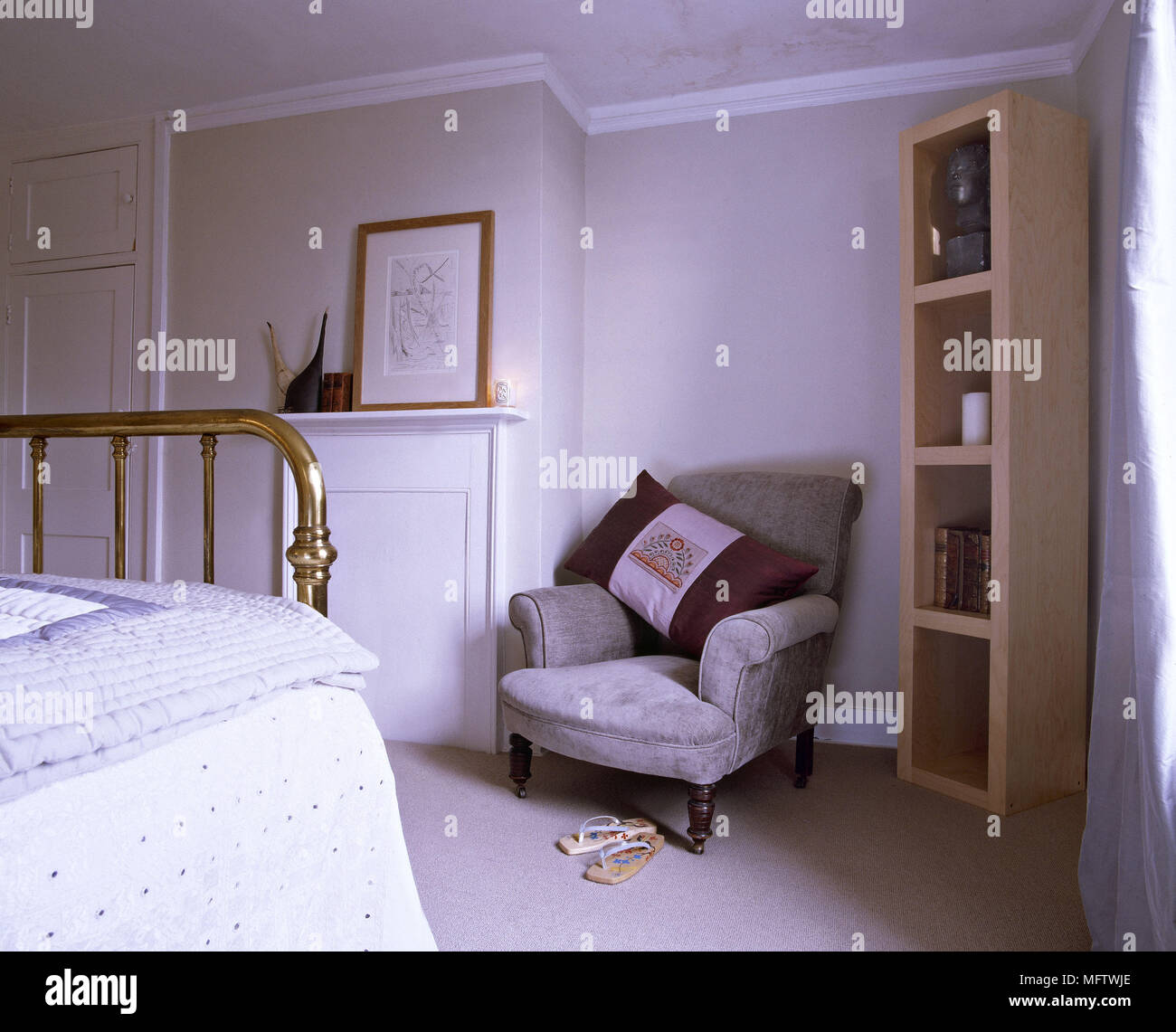 Bedroom with brass bedstead and armchair. Stock Photo