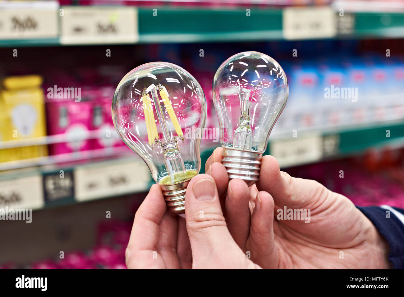 LED and incandescent lamp in the hands of the buyer in the store Stock Photo
