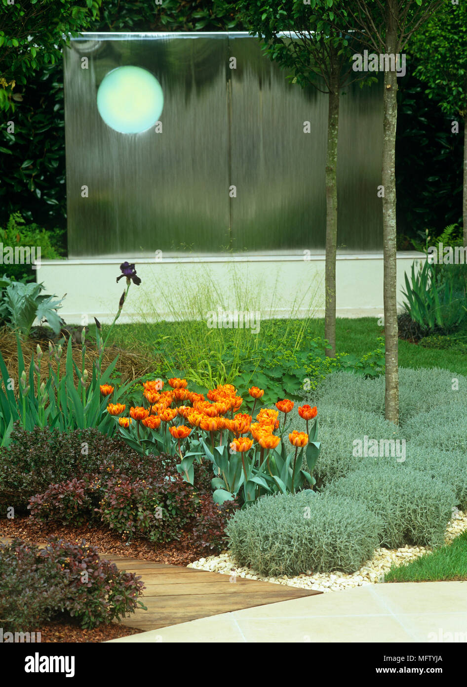 Contemporary garden with flower borders with orange tulips at the Chelsea flower show Stock Photo
