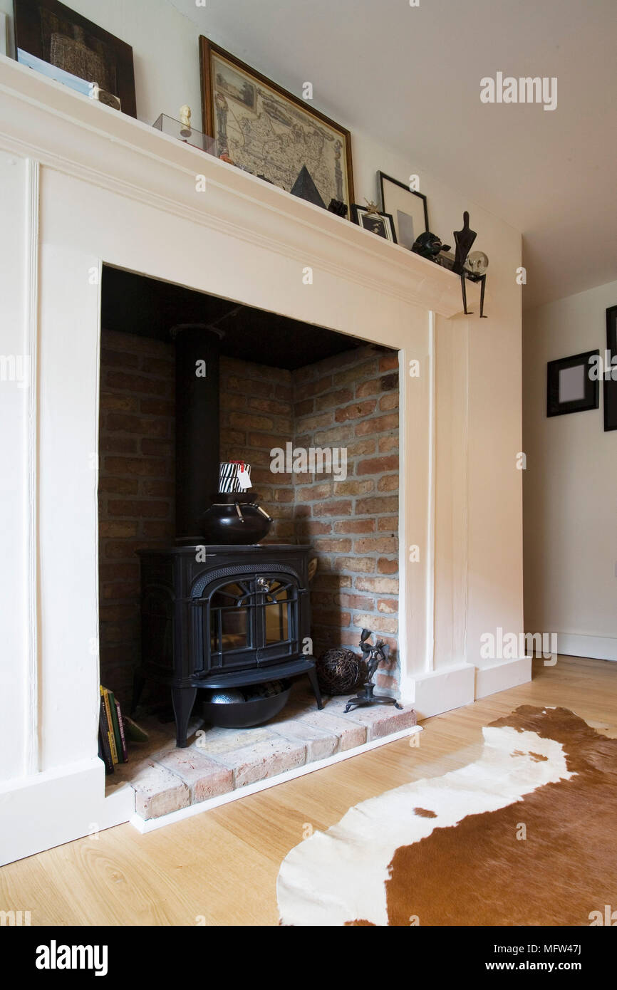 Wood Burning Stove Set In Fireplace With Painted Surround Stock