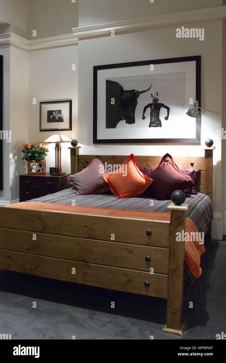 A Modern Bedroom With A Wooden Master Bed Below A Large Art