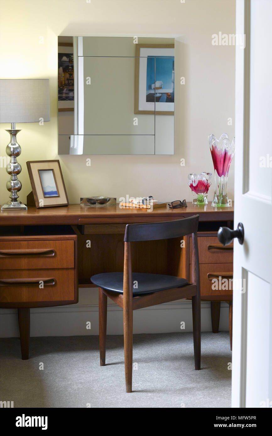 A Small Study With A Mirror Above A Retro Wooden Desk And Chair