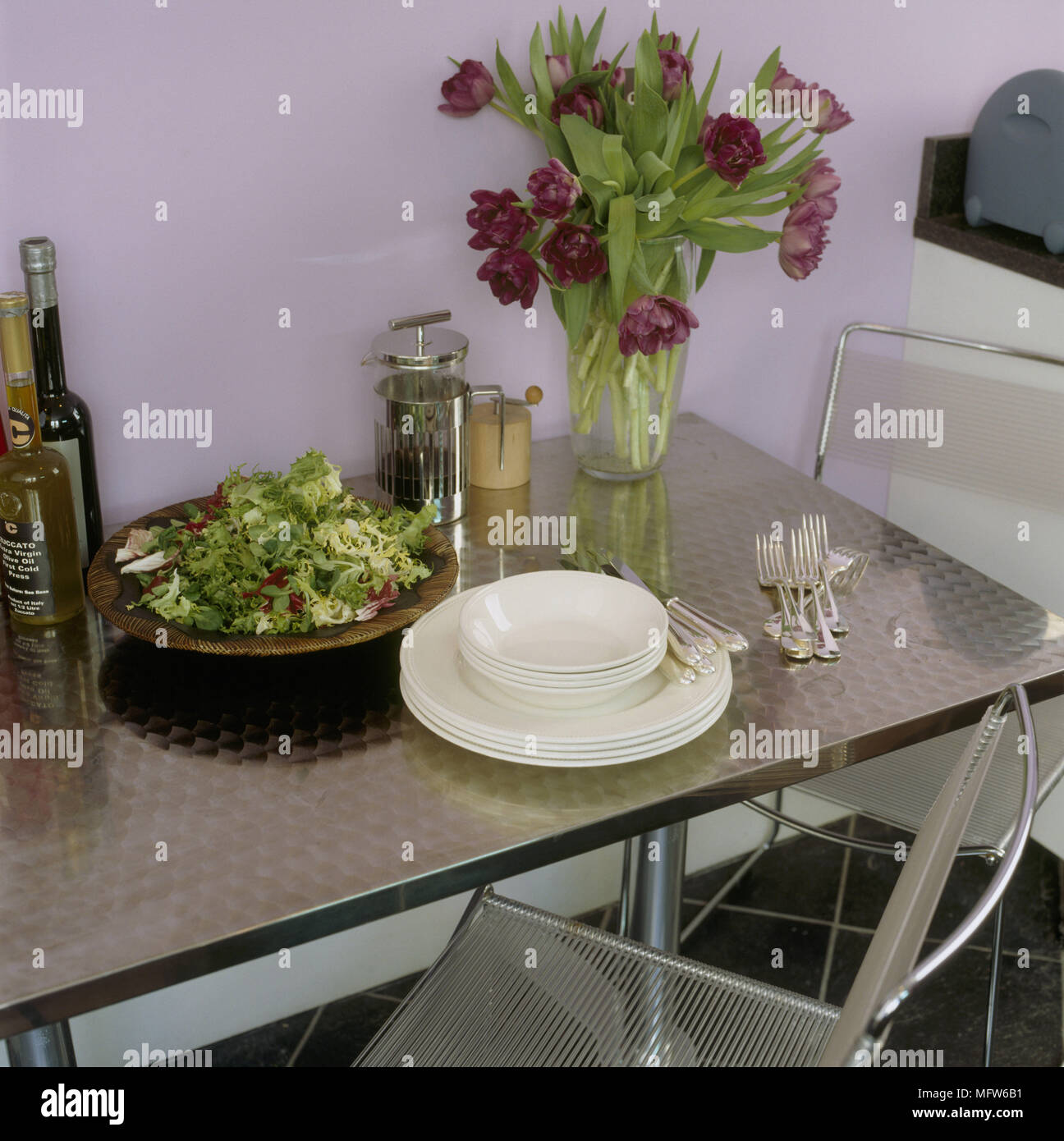 A Detail Of A Modern Dining Room Showing A Metal Table And Chairs Tableware Salad In A Bowl Tulip Flower Arrangement Stock Photo Alamy